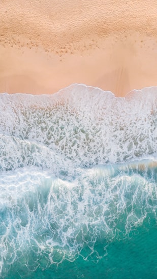 White shell sand and jade water at Porthcurno below the cliffs
