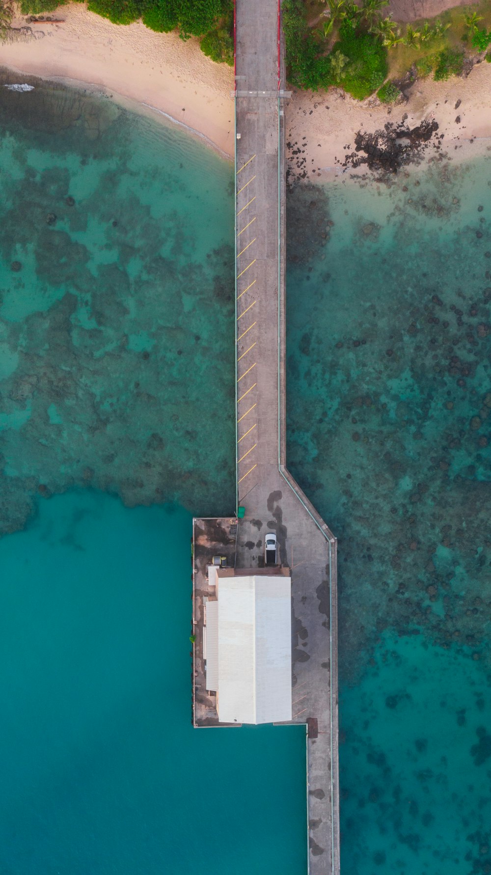 aerial view of house between blue sea