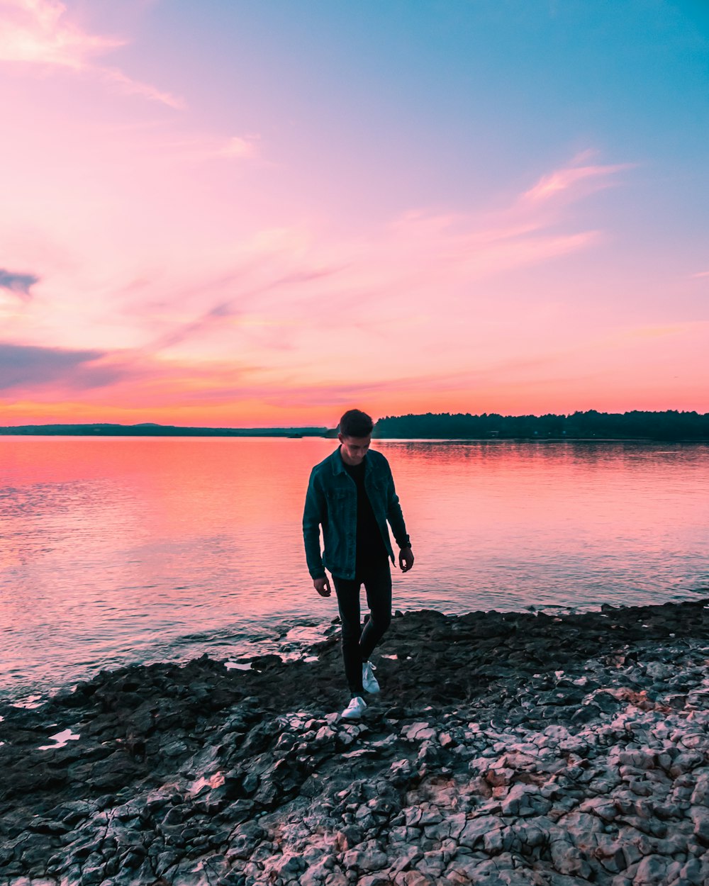 person standing near a body of water during golden hour
