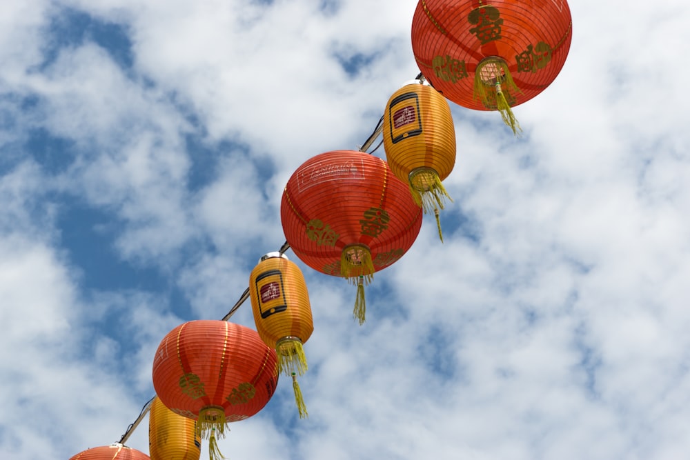 red and orange lantern lamp under white clouds and blue sky during daytime