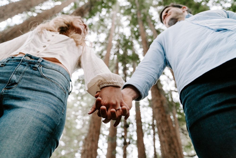 shalow focus photo of man and woman holding each others hands