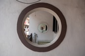 Concentric circles formed by round windows or mirrors create a tunnel-like visual effect, with a glimpse of an outdoor street scene visible through the openings.