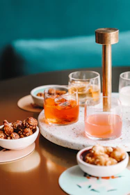 Refreshing drinks and light snacks arranged on a stylish black and gold lounge table.