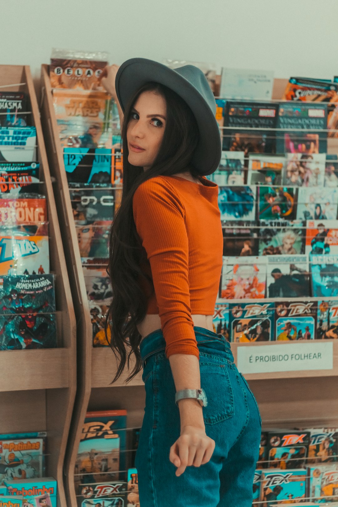 woman standing beside magazine in rack