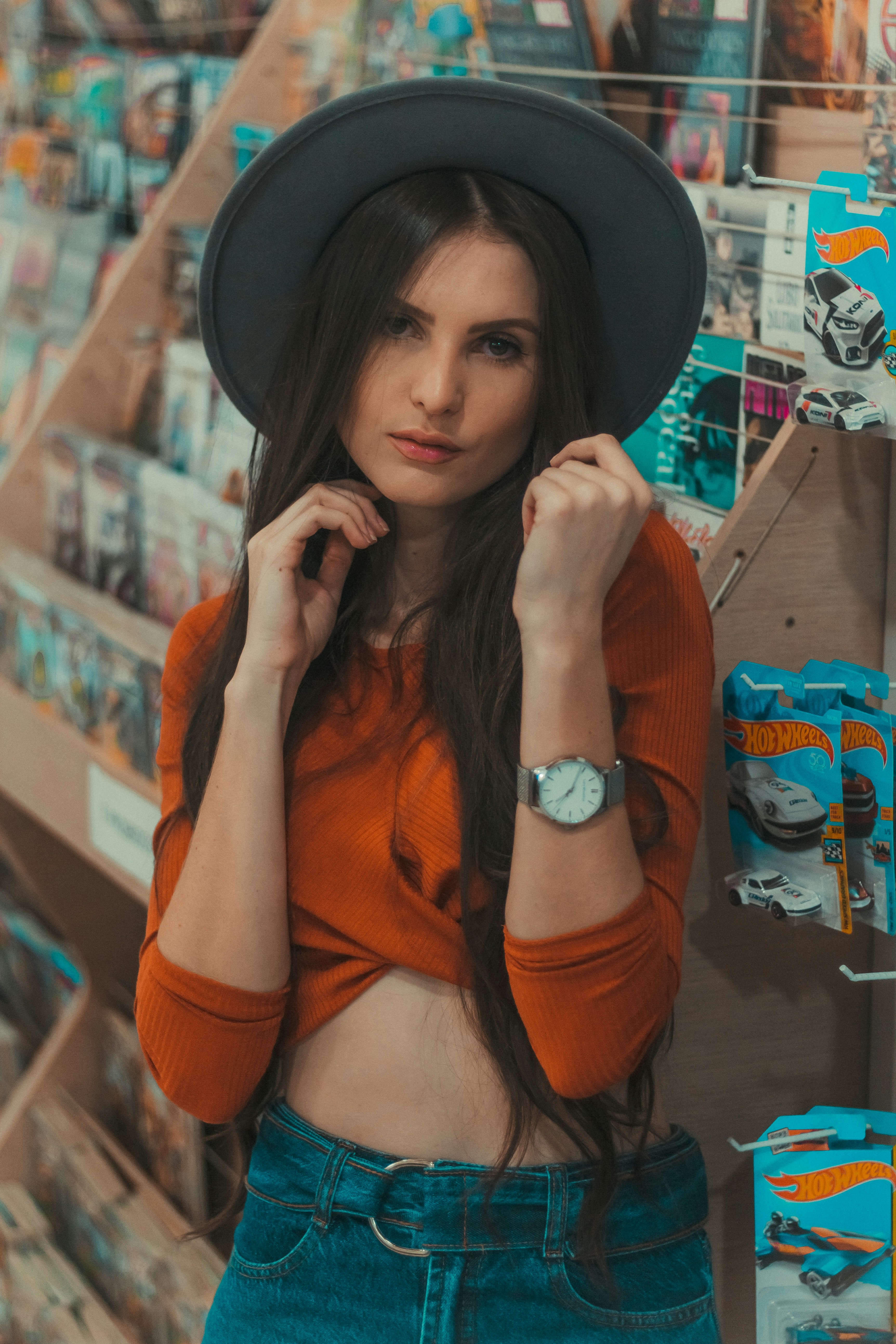 wanita mengenakan crop top oranye dan topi abu-abu