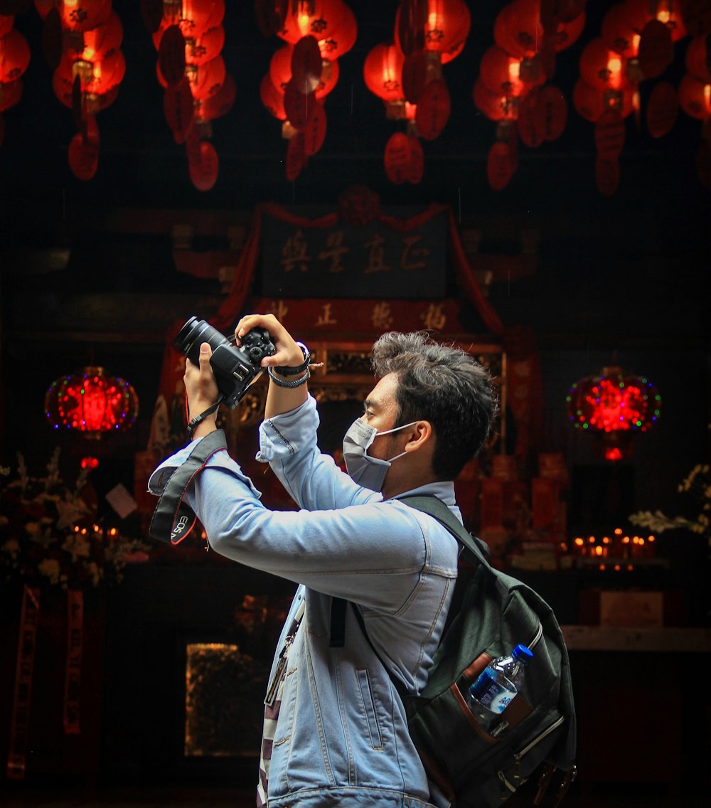 man holding camera near store