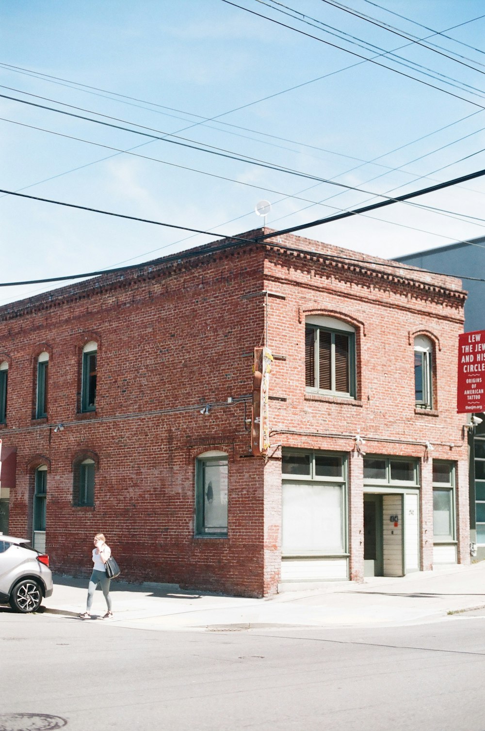 person walking near brown 2-story building