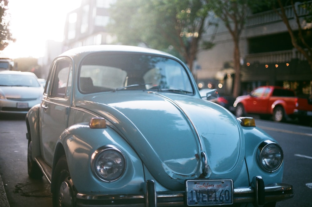 blue classic Volkswagen Beetle parked on side of road