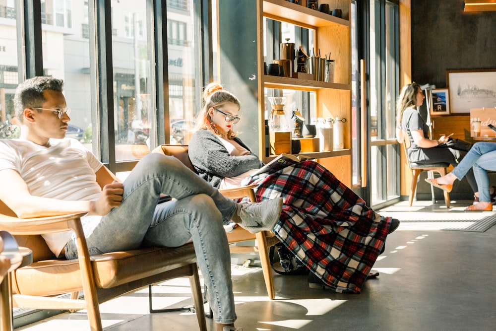 man and woman sitting on arm chairs