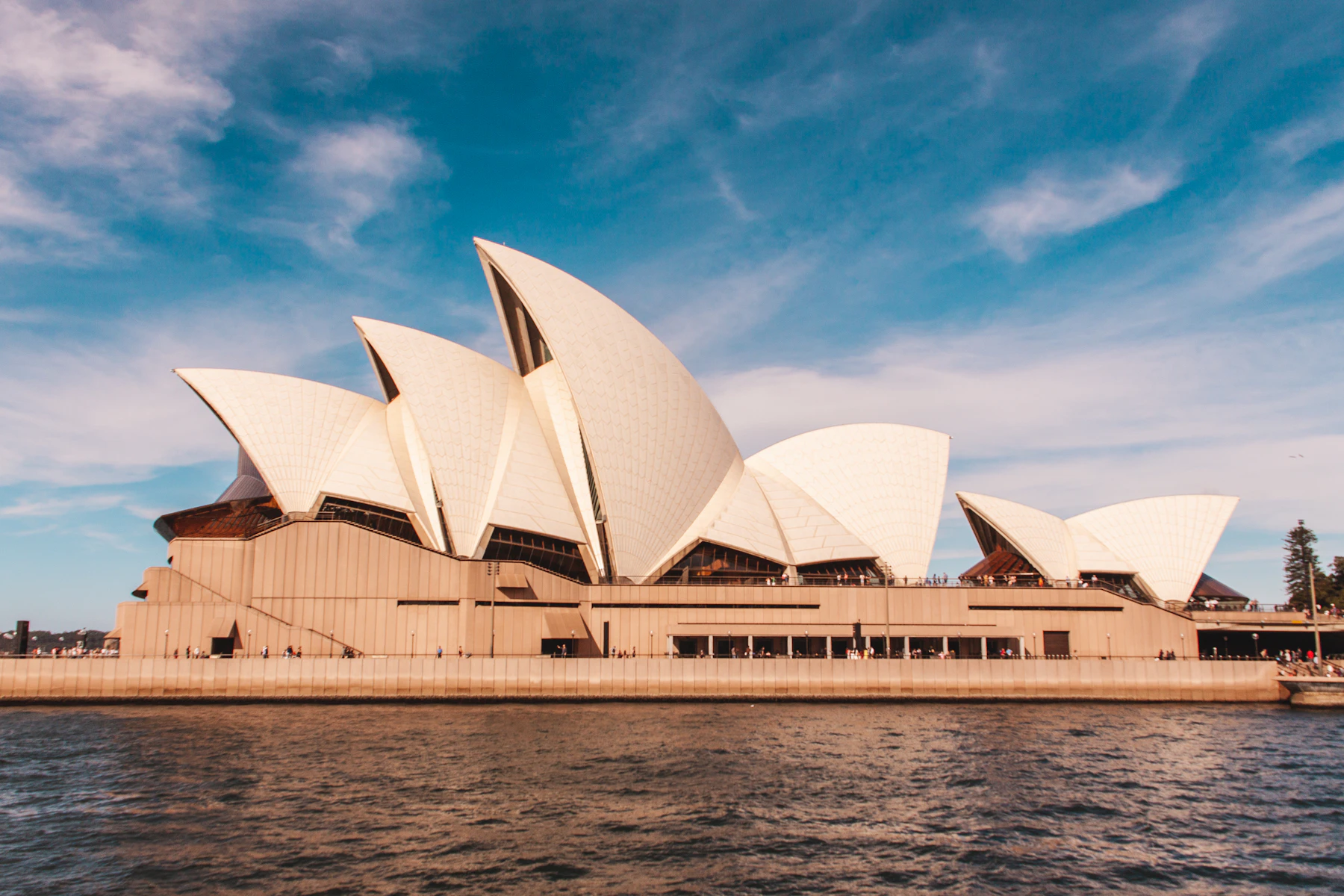 Sydney Opera House beside the harbour at dusk