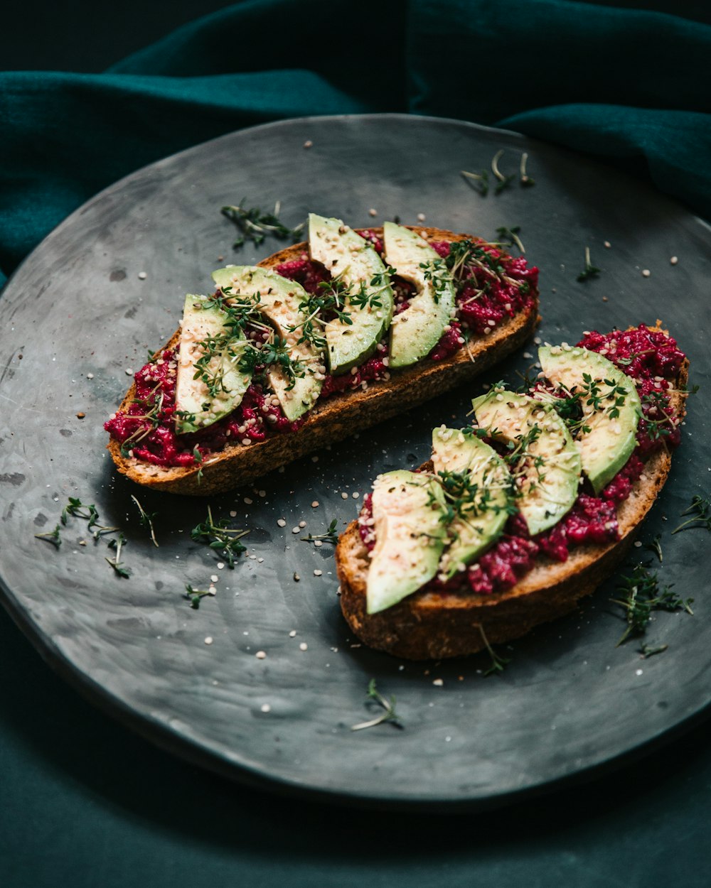 bread with sliced avocado and garnish with herbs