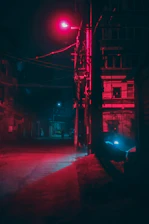Mysterious urban night scene with shadowy figure and dim street lamps.