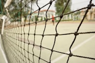 A close-up of a perimeter netting installed around a sports court.
