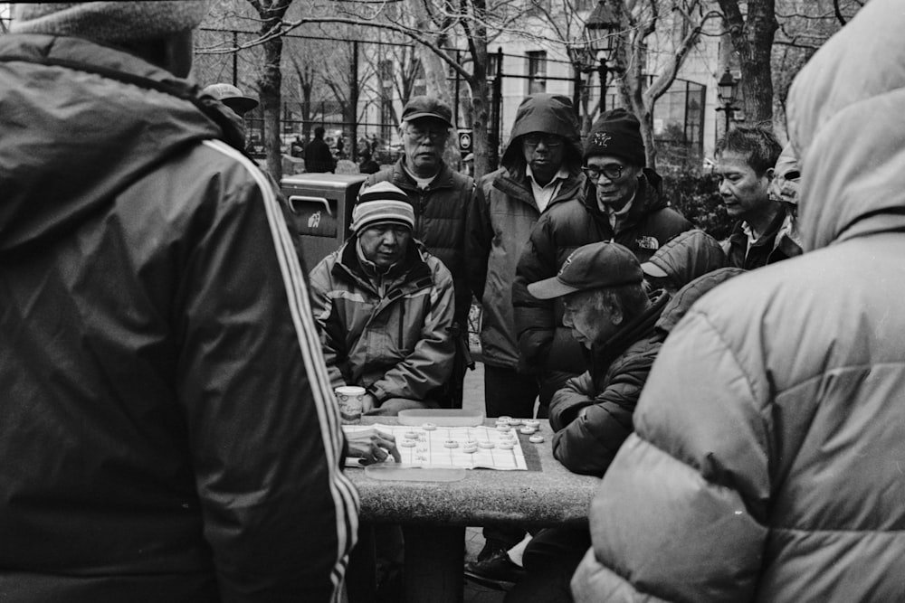 grayscale photo of people playing board game