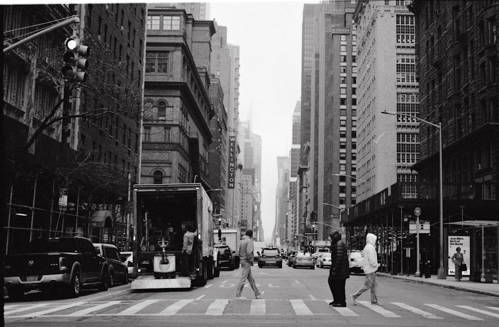 grayscale photography of people and cars on road