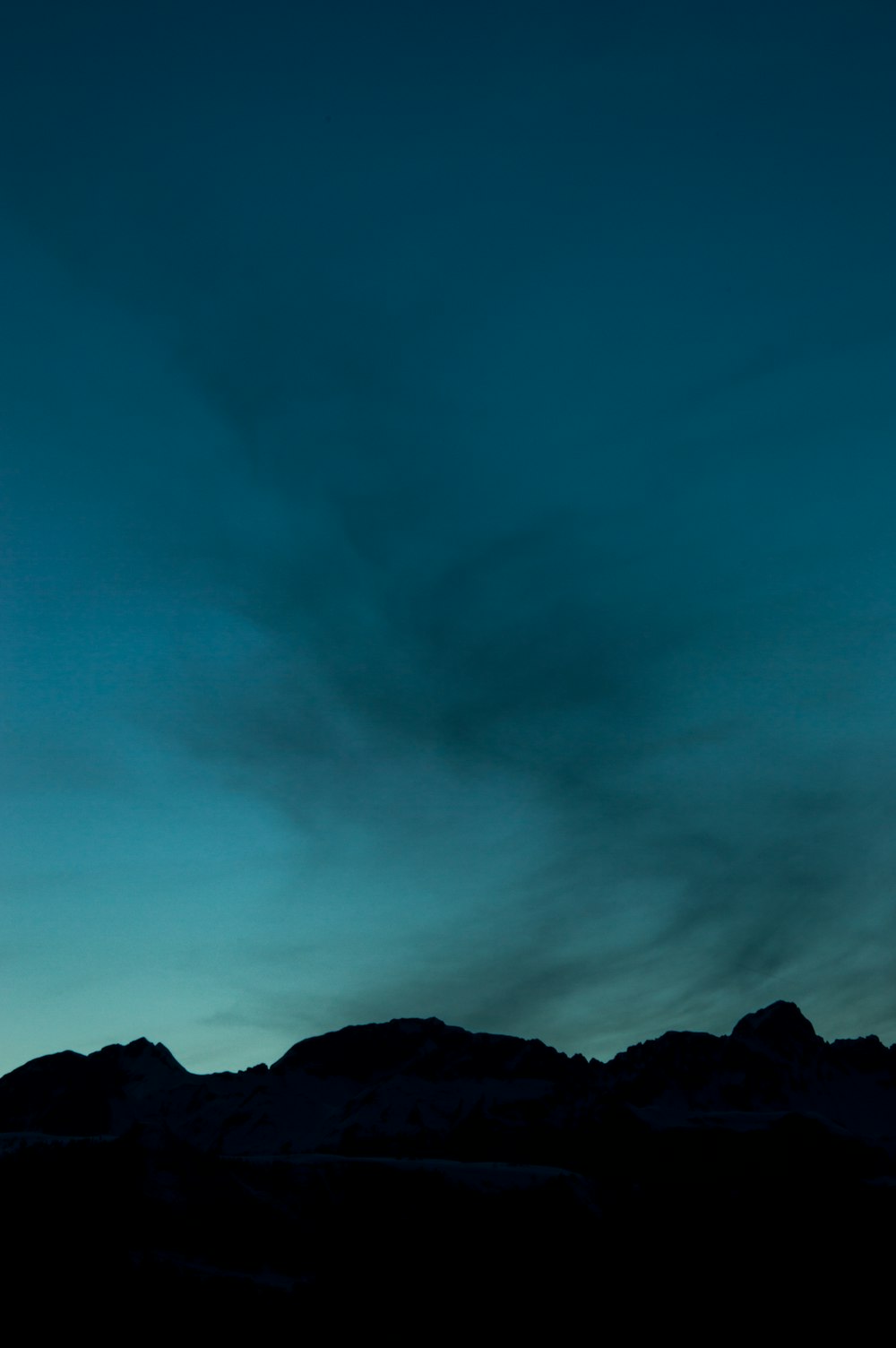 a plane flying in the sky with a mountain in the background