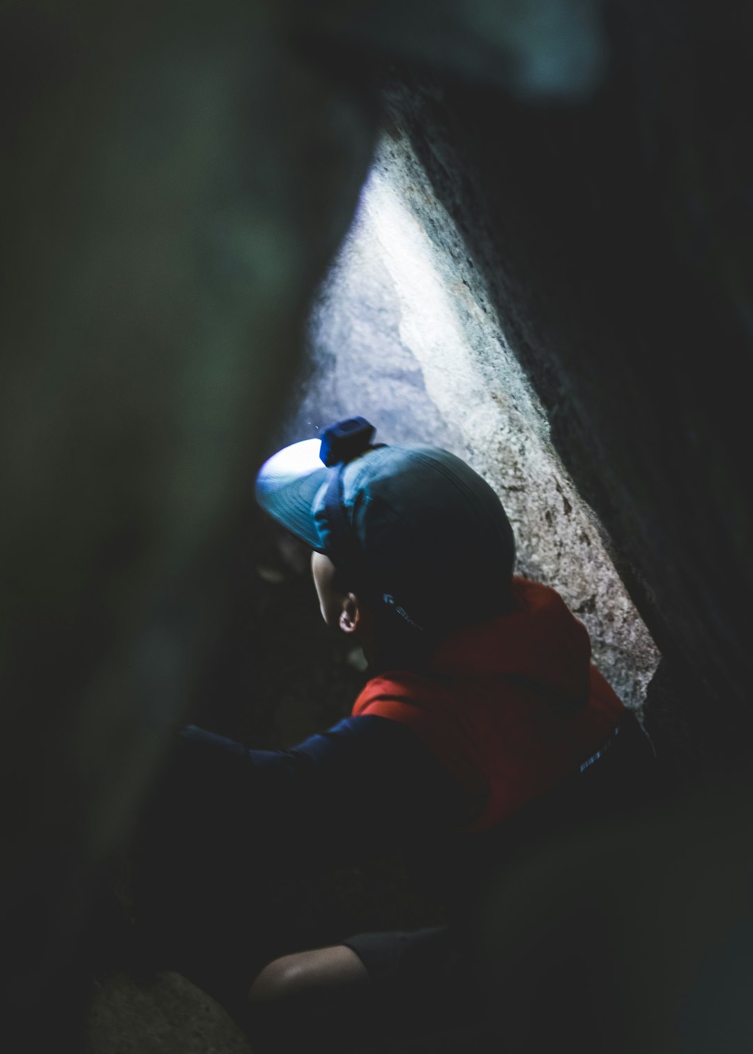 man wearing red hoodie inside cave