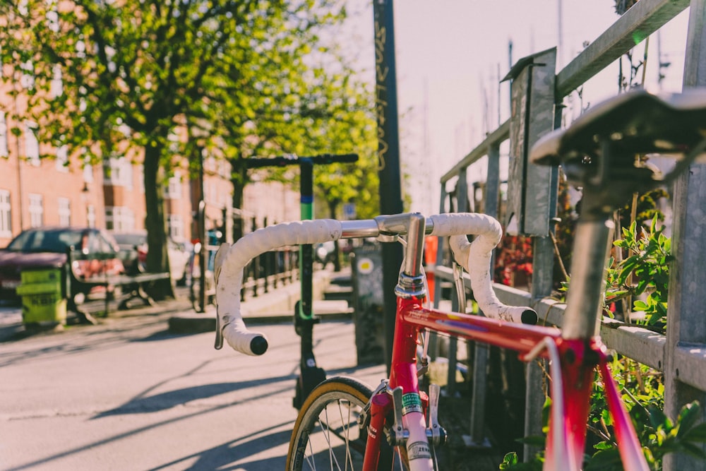 red and white road bike parked near fence