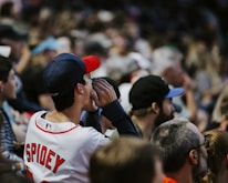A close-up of a person wearing a custom sports jersey while cheering at a game.