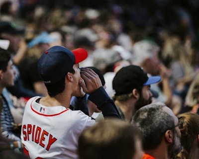 A close-up of a person wearing a custom sports jersey while cheering at a game.