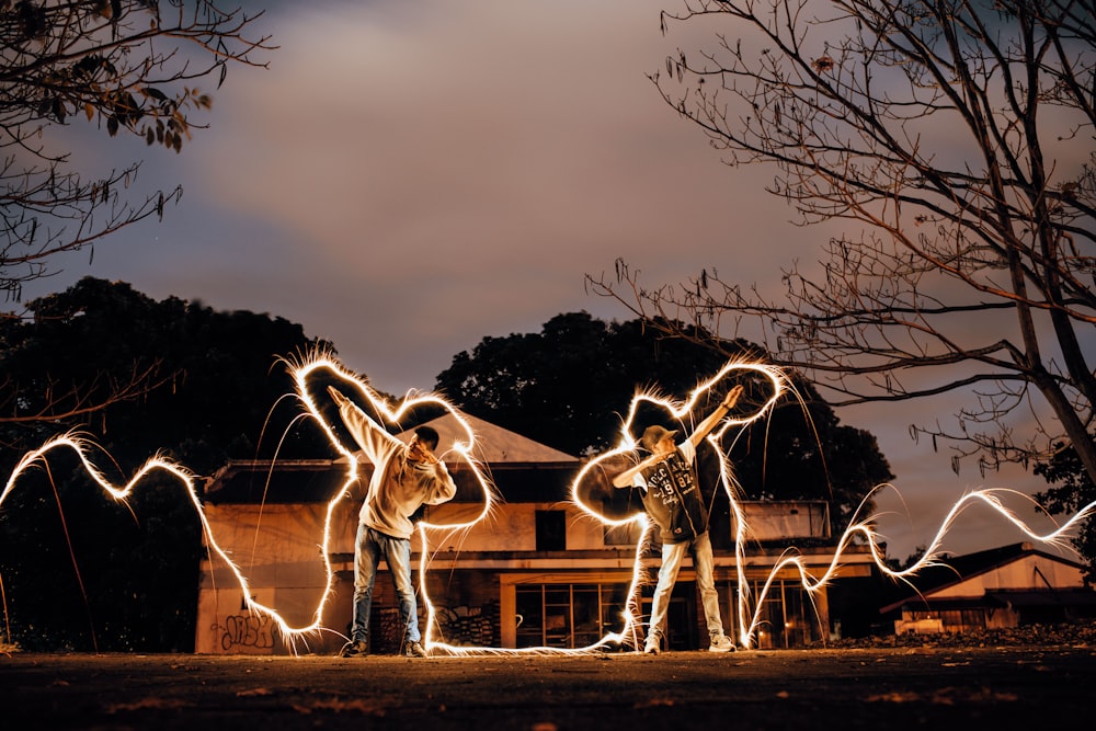 two men lifting one arm with LED lights