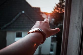 Close-up of a sleek, modern Swissebene watch on a city rooftop at sunset