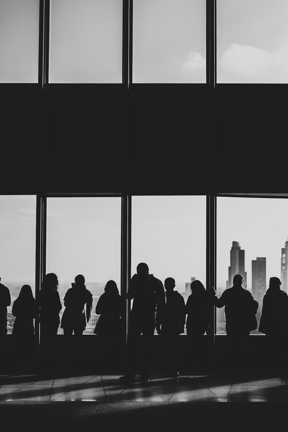 silhouette of people looking at windows