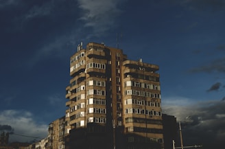 Aerial drone shot capturing a sleek, dark luxury apartment building in Bogotá at dusk.