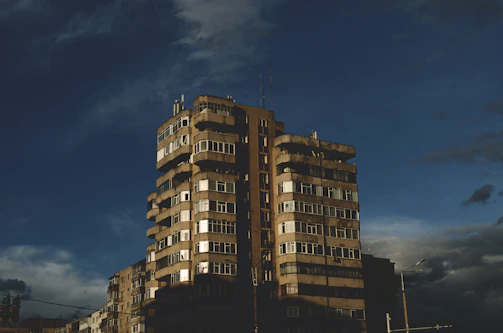 A luxury urban apartment building with reflective glass facade under a moody sky.