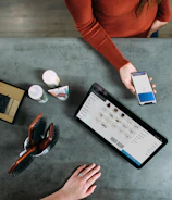 person holding smartphone beside tablet computer