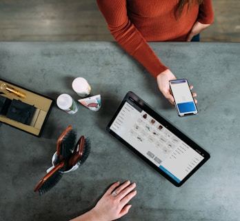 person holding smartphone beside tablet computer