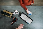 person holding smartphone beside tablet computer