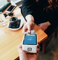 person holding credit card swipe machine