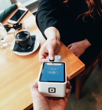 person holding credit card swipe machine