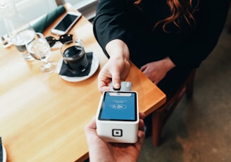 person holding credit card swipe machine