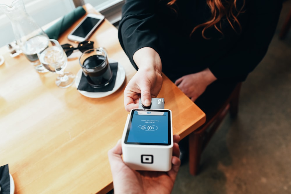 person holding credit card swipe machine