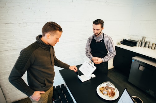 man looking at white digital device