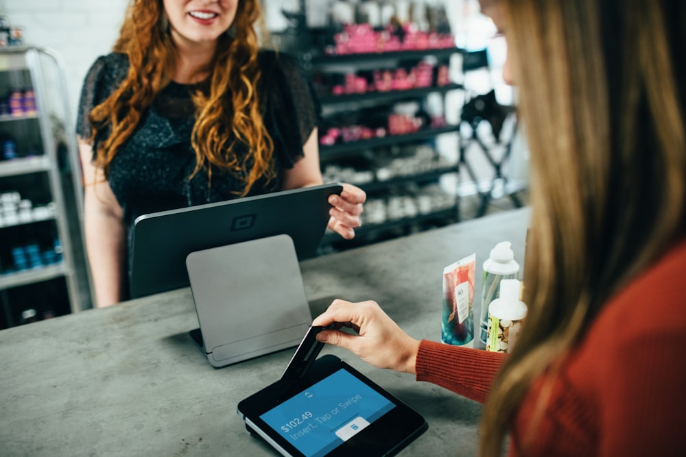 woman doing a business transaction and swiping her card