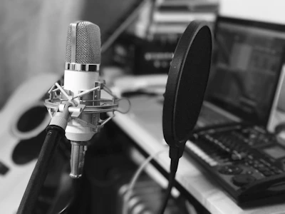 Close-up of a professional microphone with pop filter in a recording booth