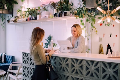 woman facing on white counter store teams background