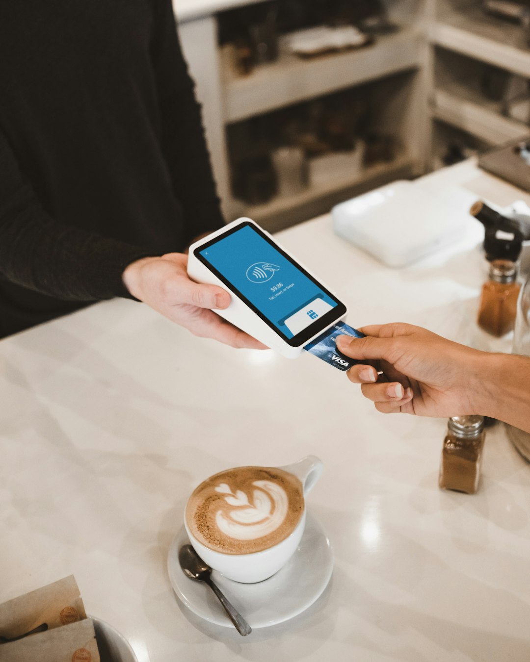 A person's hands holding a smartphone with a mobile payment app on the screen, set against a blurred background.