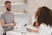 man in grey crew-neck t-shirt smiling to woman on counter
