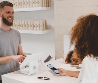 man in grey crew-neck t-shirt smiling to woman on counter