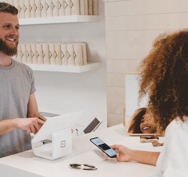 man in grey crew-neck t-shirt smiling to woman on counter