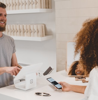 man in grey crew-neck t-shirt smiling to woman on counter