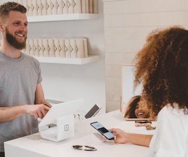 man in grey crew-neck t-shirt smiling to woman on counter