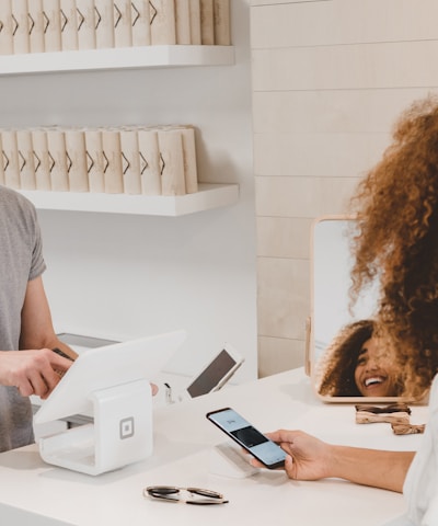 man in grey crew-neck t-shirt smiling to woman on counter