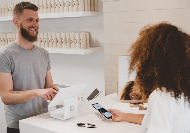 man in grey crew-neck t-shirt smiling to woman on counter