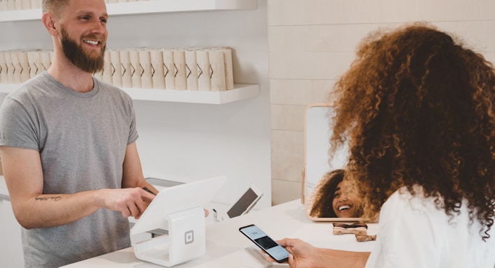 man in grey crew-neck t-shirt smiling to woman on counter