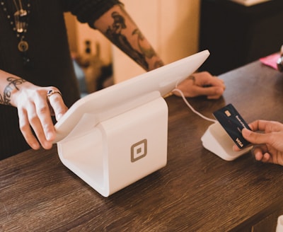 person holding white POS machine